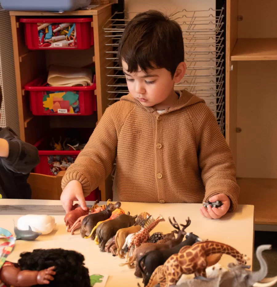 Jongen peuterspeelzaal Bereboot spelen met dieren