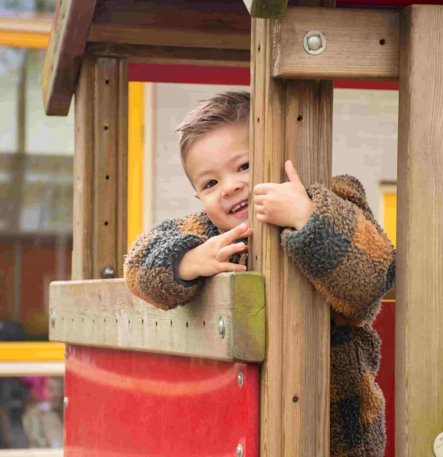 Jongen in speelhuisje