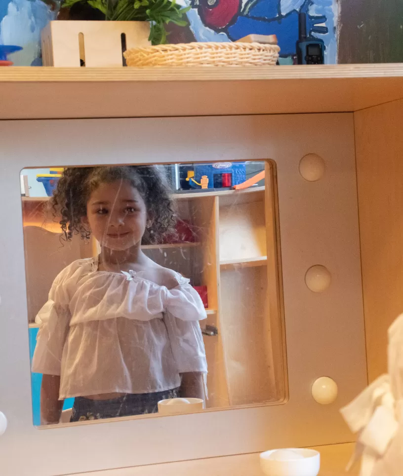 Meisje kijkt in de spiegel