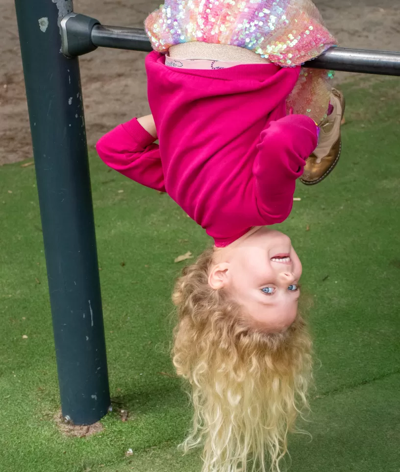 Meisje onderste boven op rek