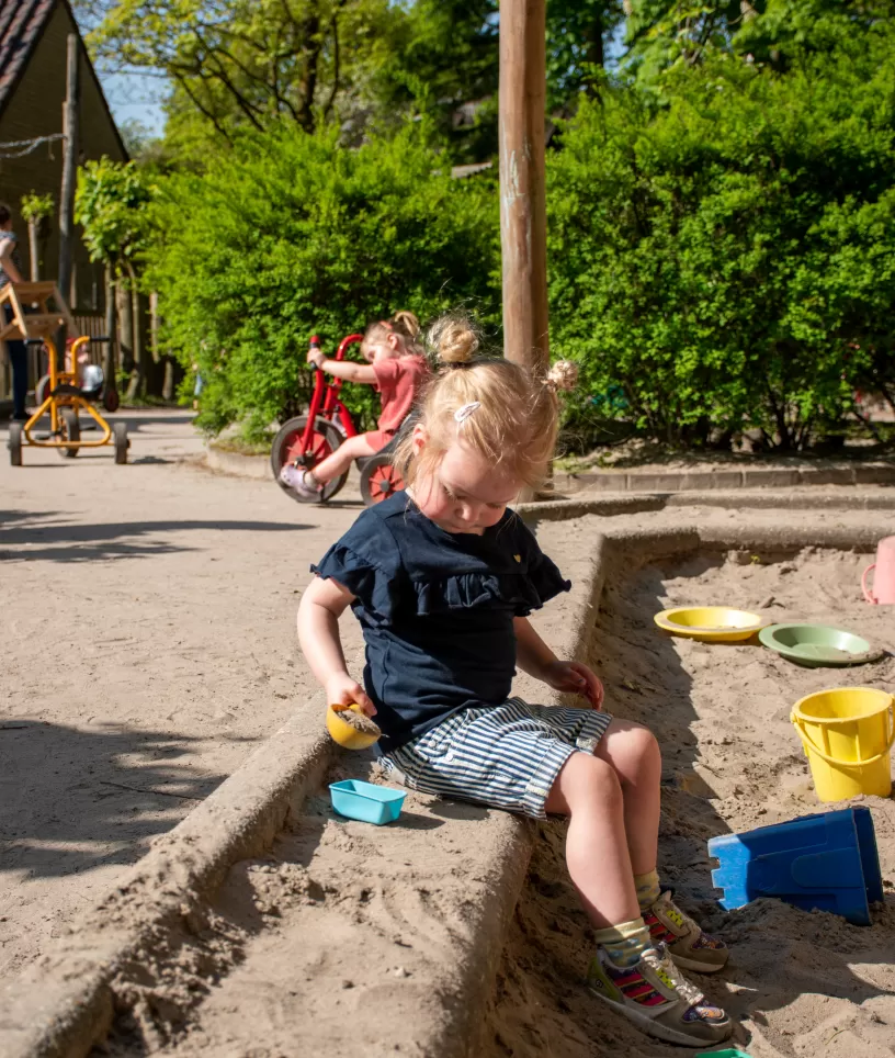 Meisje bij zandbak