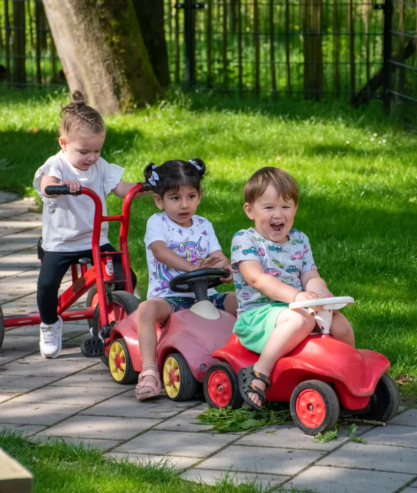 Kinderen op rode auto's en step