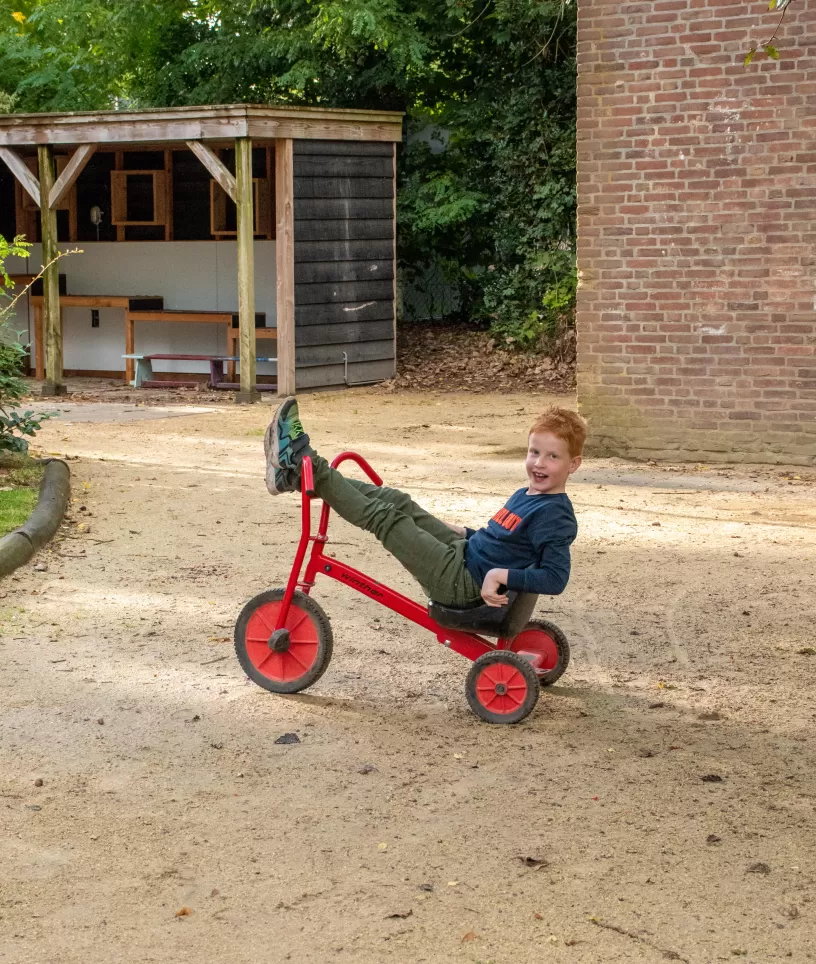 Bso Kasteel tuin jongen op rode fiets