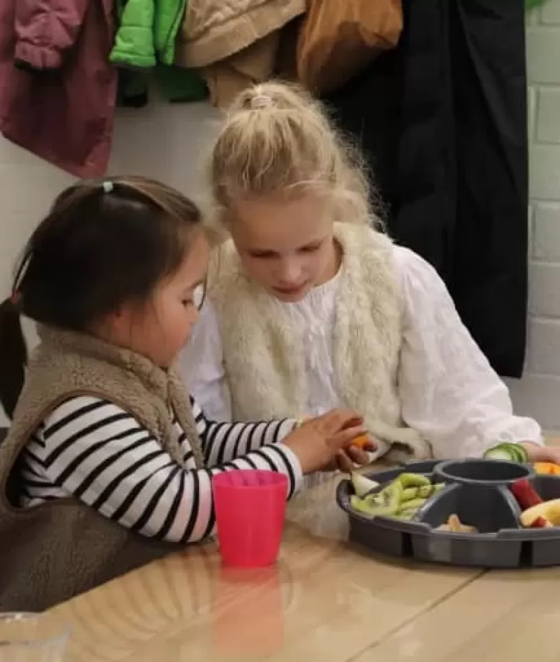 twee meisjes eten fruit