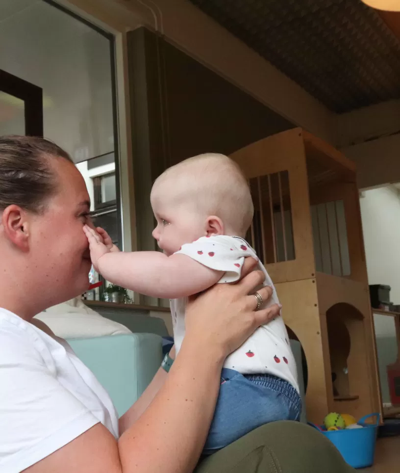 Pedagogisch medewerkster speelt met baby