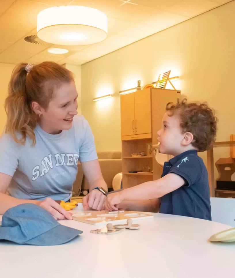 Pedagogisch medewerker met kind spelen