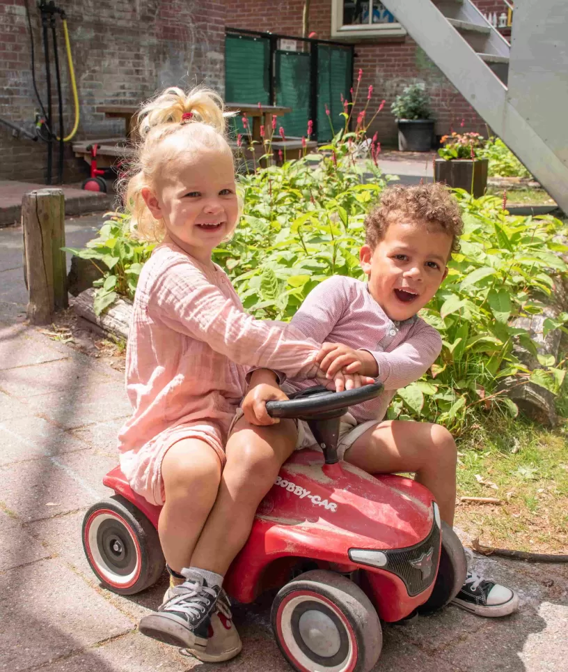 Jongen en meisje op loopauto