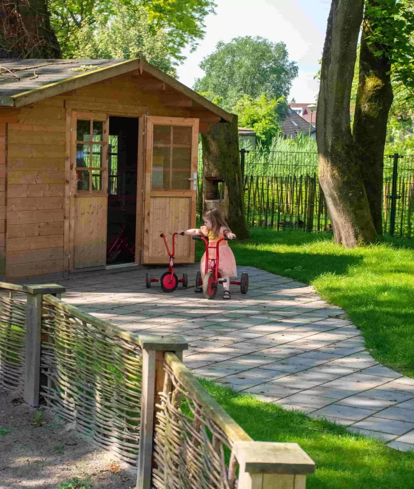Schuur met meisje met rode stepjes