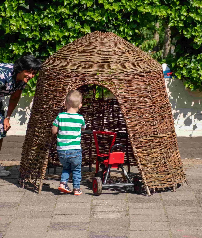 Pedagogisch medewerker met jongen bij de hut