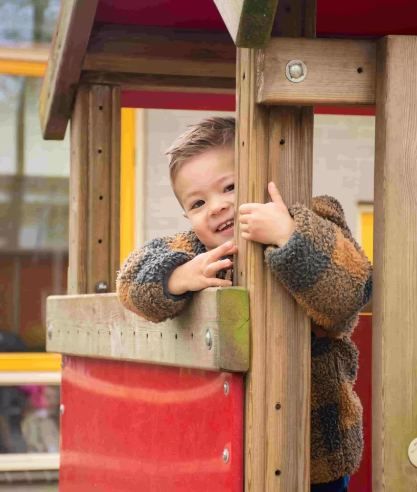 Jongen in speelhuisje
