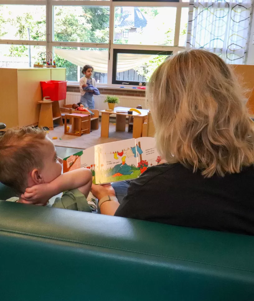 medewerker leest kind voor